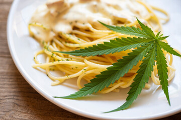Cannabis food nature herb concept, Spaghetti carbonara on plate with cannabis leaf - marijuana...