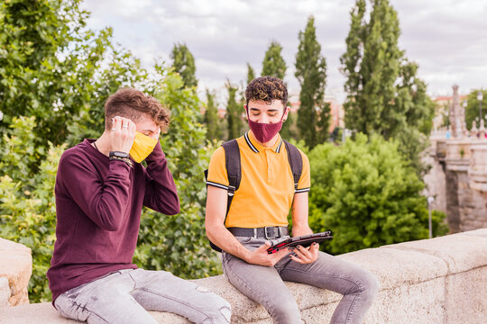 Latin Young Man And Non Binary Transgender Friends Using Technology For Social Distance In New Normal