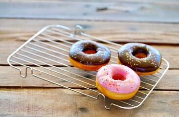 testy Strawberry and chocolate donut on grille and wood table - obrazy, fototapety, plakaty