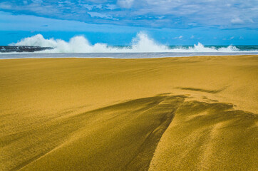 Abstract patterns on a glistening golden beach on the shores of Kauai, Hawai