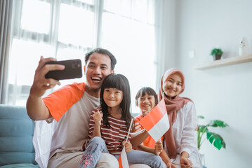 indonesian muslim asian family making selfie and video call using their phone at home