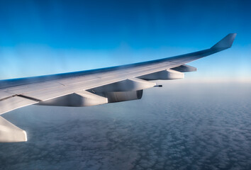 Airplane wing during flight at sunset