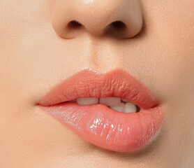 Beautiful young woman biting lip on grey background, closeup