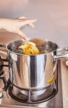 Teenager Cooks Pasta For Making Spaghetti Bolognese According To Recipe From The Internet