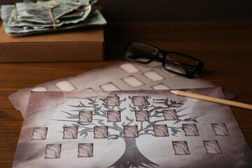 Papers with family tree templates, pencil, photos and glasses on wooden table, closeup - obrazy, fototapety, plakaty