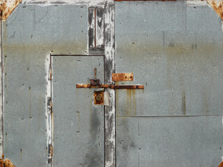 Old private garage. Rusty metal doors of an old garage.