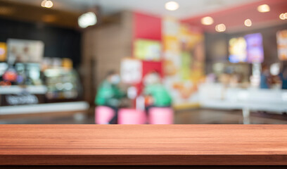 wood table in blurry background with fast food restaurant or coffee shop ,nature orange bokeh and sunlight in morning.