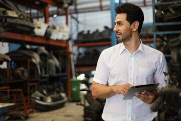 Fototapeta premium Businessman using laptop computer working or checking stock in warehouse factory, entrepreneurship or business owner concept