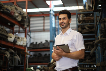 Businessman using laptop computer working or checking stock in warehouse factory, entrepreneurship or business owner concept