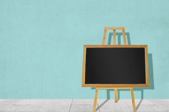 Small chalkboard on a wooden easel with a colored wall background