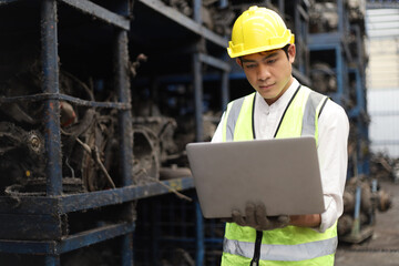 Worker or Engineer work in factory and talk using laptop computer for check stock and inspection in machine spare part engine warehouse