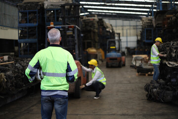 Back side of Worker or Engineer work in factory and talk with team by radio, Check stock and inspection in machine spare part engine warehouse