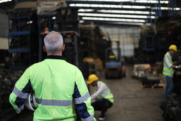 Back side of Worker or Engineer work in factory and talk with team by radio, Check stock and...