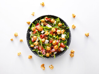 Obraz na płótnie Canvas Plate with tasty popcorn salad on white background