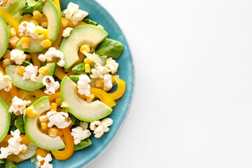 Plate with tasty popcorn salad on white background