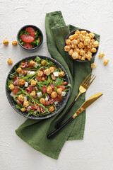 Plate with tasty popcorn salad on light background