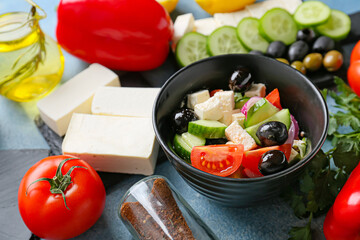 Bowl with tasty Greek salad on color background, closeup