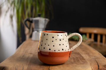 cup of coffee with mocha pot on a wooden table