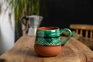 cup of coffee with mocha pot on a wooden table