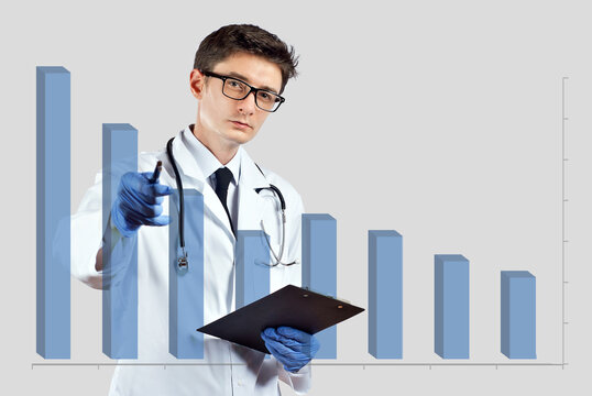 The doctor looks at the descending chart. The concept of reducing morbidity, vaccination and mortality. A man in a doctor's suit on a white background. - Powered by Adobe
