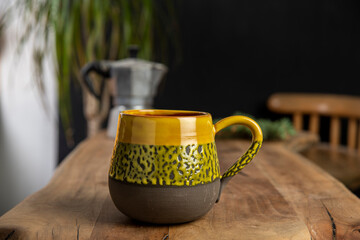 cup of coffee with mocha pot on a wooden table