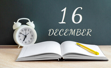 december 16. 16-th day of the month, calendar date.A white alarm clock, an open notebook with blank pages, and a yellow pencil lie on the table.Winter month, day of the year concept