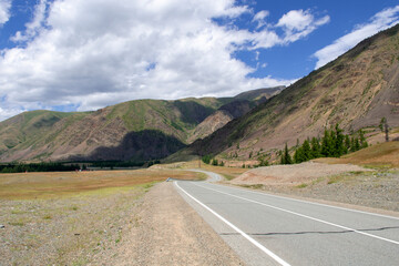 Fototapeta premium mountains against the background of clouds and the road stretching into the distance