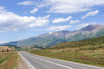 mountains against the background of clouds and the road stretching into the distance