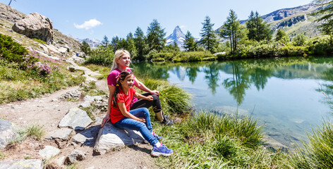 Fototapeta premium Happy hiker woman and girl at mountains lake