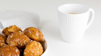 french chouquettes puffs with perles of sugar on plate with white cup of coffee. Choux pastry Classic French bakeries. 
