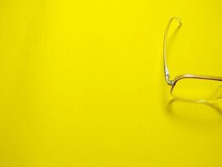 Eyeglasses on yellow background copy space. Gives the concept of wearing eye protection glasses in...