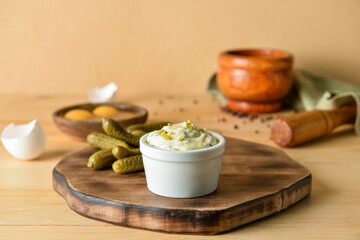 Bowl with tasty tartare sauce and pickled cucumbers on color background
