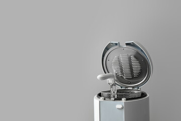 Modern deep fryer on light background