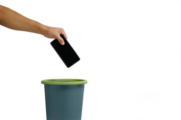 Man hand throws cell phone into trash can on white background. - obrazy, fototapety, plakaty