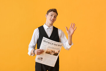 Young businessman with newspaper on color background