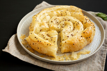 Homemade Balkan Pie with Feta and Sesame Seeds on a plate, side view.