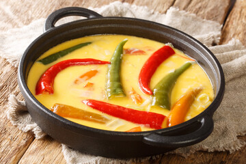 Green and red chillies abound in Ema datshi it is made from hot chili peppers and yak cheese closeup in the pan on the table. horizontal