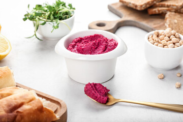 Composition with tasty beet hummus and ingredients on light background