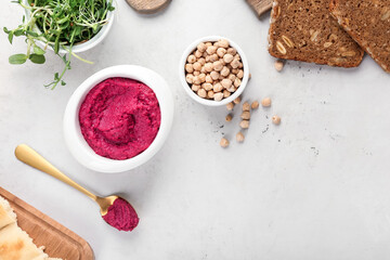 Composition with tasty beet hummus and ingredients on light background