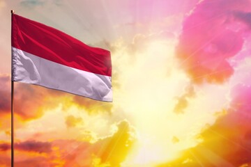 Fluttering Indonesia flag in top left corner mockup with the space for your text on beautiful colorful sunset or sunrise background.