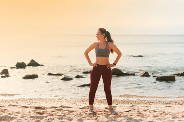 Photo of happy sports woman smiling and looking away, beach at sunset lights