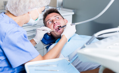 Young man on dental checkup in modern dentist office