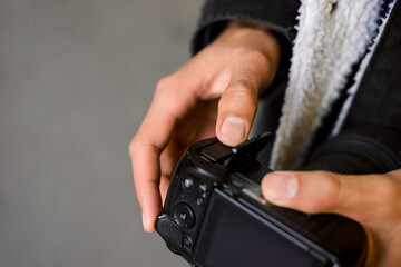 Close up shot of hands of a man putting a battery into the camera. Copy space, professional shooting, photographer.