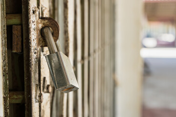 Old master key locked on iron gate, Steel padlock, Close up selective focus, Soft background blur.