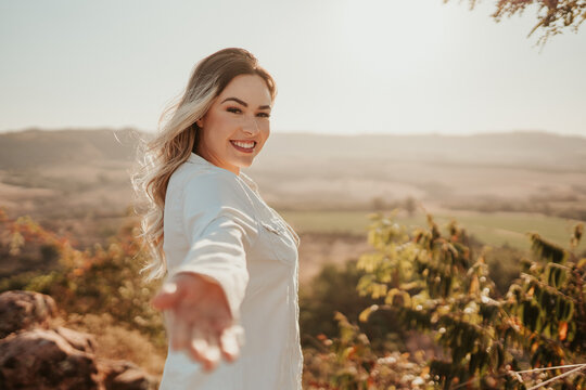 Latin woman reaching out to camera, inviting to a trip. Come with me.
