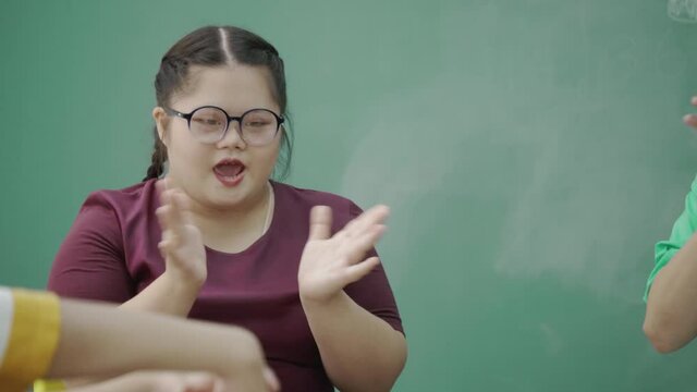 Autistic Asian girl sit in classroom with teacher and friend to do learning. young are happy doing activities to enhance knowledge skills. confidence to live together. Concept assertive