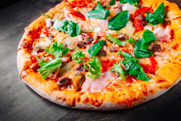 Pizza with Mozzarella cheese, Bolognese sauce, minced meat, bacon, tomato and vegetables. Italian pizza on wooden background.