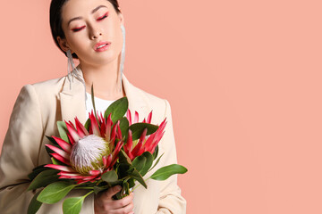 Beautiful young woman with protea flowers on color background