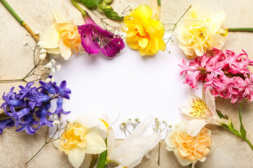 Frame made of beautiful flowers and blank card on grunge background, closeup