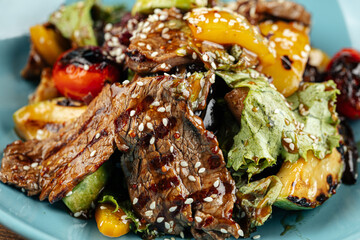 Blue plate of grilled veal meat with vegetables